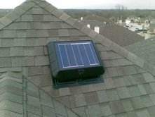 Solar attic fan on a roof cooling an attic and a home