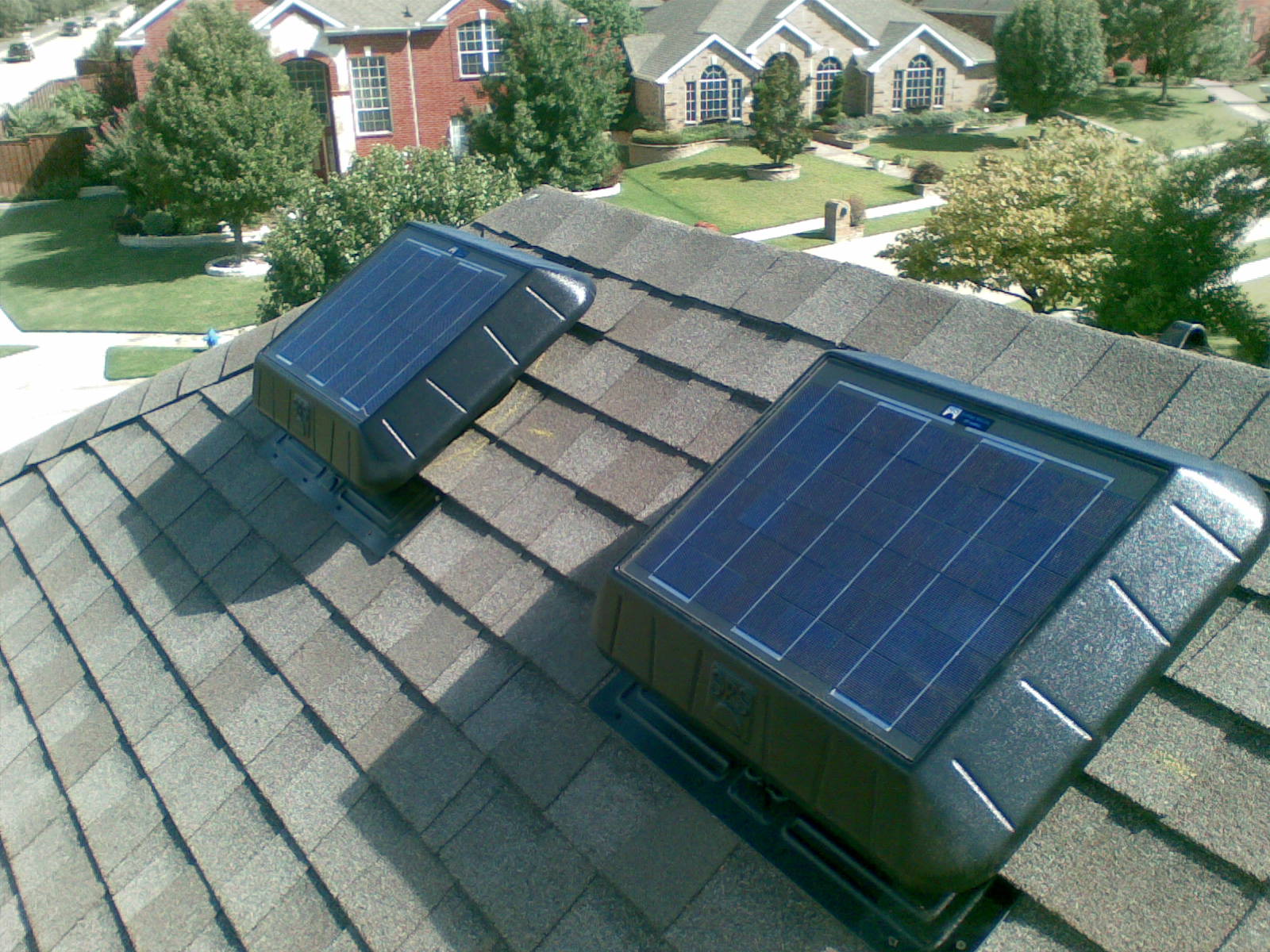 Two solar attic fan on a roof cooling an attic and a home